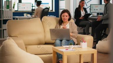 业务女人会说话的<strong>视频</strong>会议调用移动PC坐着沙发上